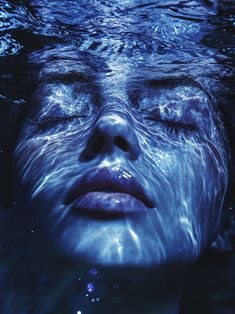 a woman is submerged in the water with her eyes closed