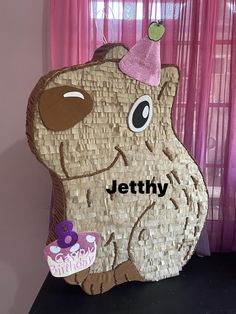 a paper cut out of a bear holding a cupcake with the name jettty on it