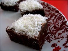 three pieces of chocolate cake with coconut toppings on a red and white floral plate