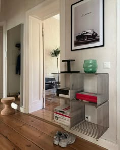 a pair of shoes sitting on top of a wooden floor next to a shelf filled with books