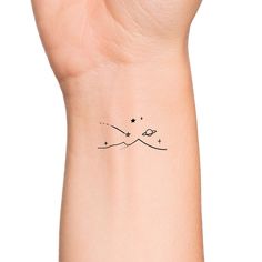 a wrist tattoo with stars on it and a star in the sky above its arm