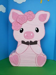 a paper cut out of a pig with flowers on it's head, sitting in front of a blue background