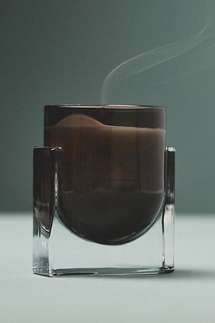 a glass cup with steam rising out of it