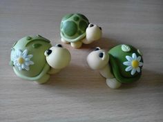 three little turtle figurines sitting on top of a wooden table next to each other