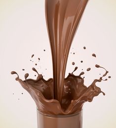 a glass filled with chocolate milk and splashing it's contents into the air