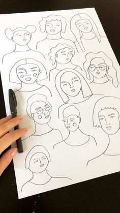 someone is drawing faces on a piece of paper