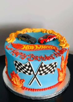 a birthday cake decorated with racing cars on fire and flames is ready to be eaten