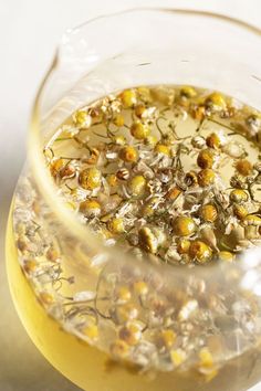 a glass filled with yellow flowers on top of a table