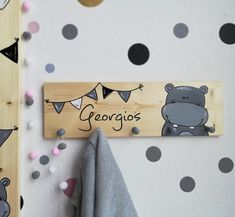 a wooden sign that says gergios hanging on a wall with polka dot dots