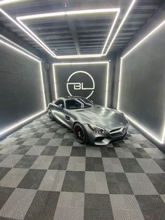 a car is parked in the middle of a checkered floored area with neon lights