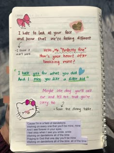 an open notebook with writing on it and a hello kitty note attached to the page