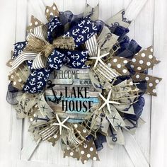 a wreath made out of burlocks and ribbons with the words welcome to lake house on it