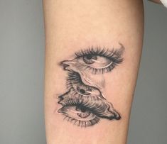 a woman's leg with an eye and eyelashes tattoo on the side of her thigh