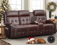 a dog laying on the floor next to a couch with a christmas hat on it