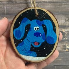 a hand painted wooden ornament with a blue dog on it