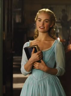 a woman in a blue dress holding a book