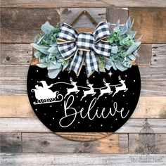 a black and white christmas door hanger with santa's sleigh