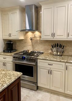 a kitchen with white cabinets and granite counter tops