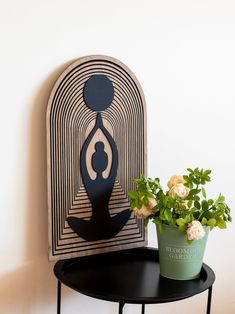 a potted plant sitting on top of a black table next to a wooden sign