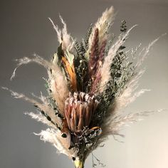 an arrangement of dried flowers in a vase