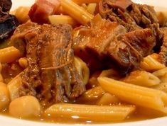 a white plate topped with pasta and meat