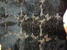 a close up of a black lace fabric with flowers on the top and bottom part