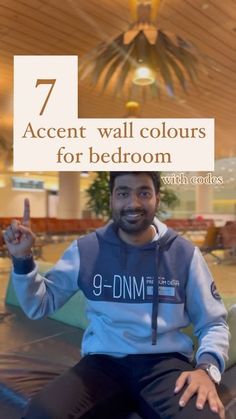 a man sitting on a bean bag chair with the text 7 accent wall colours for bedroom