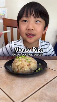 a little boy sitting at a table with rice and vegetables