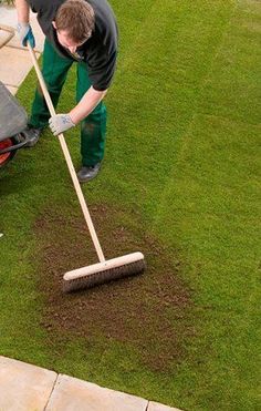 a man is cleaning the grass with a mop