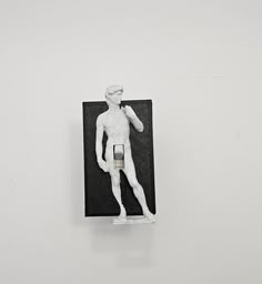 a small white statue is hanging on the wall