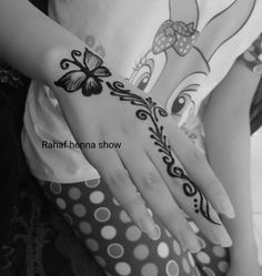 a woman's hand with henna tattoos on it and polka dots around the wrist