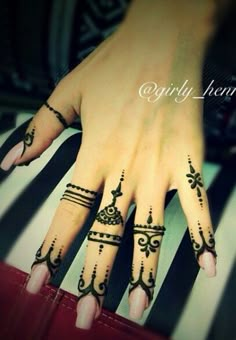 a woman's hand with henna tattoos on it