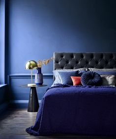 a bedroom with blue walls and purple bedding