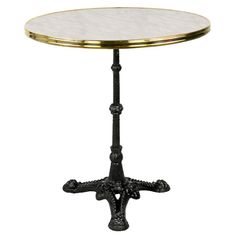 a round table with an iron base and marble top