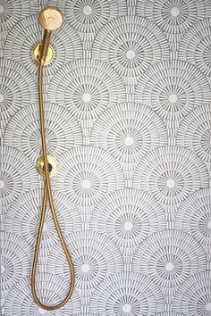 a shower head and hand held shower faucet in front of a patterned wall