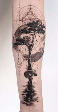 a man's leg with a tree and compass tattoo on the side of it