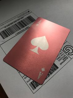 two red playing cards sitting on top of some white envelopes with barcode stickers