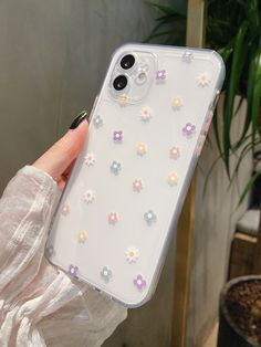 a woman holding up her phone case with flowers on the front and back cover in clear