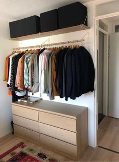 an organized closet with clothes hanging on the wall