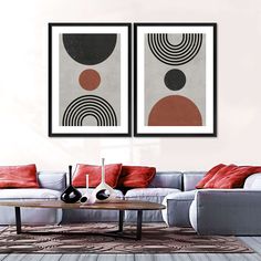 two abstract paintings hang above a couch in a living room