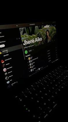 an open laptop computer sitting on top of a black surface with the screen lit up