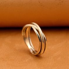 two silver rings sitting on top of a brown leather surface