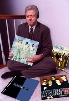 a man sitting on the floor with some records and cds in front of his face