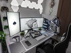 two computer monitors sitting on top of a desk next to a keyboard and monitor screen