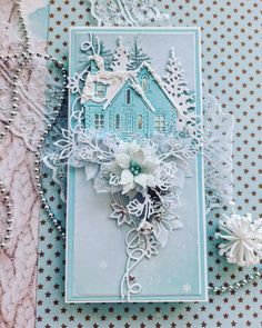 a blue card with white snowflakes on it and a house in the background