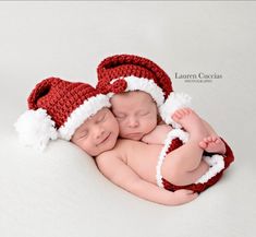 two newborn babies wearing santa hats on top of each other