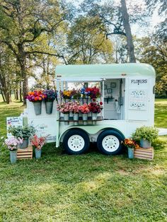 an ice cream truck with flowers on the side and potted plants at the front