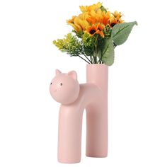 a pink vase with yellow flowers and a cat figure