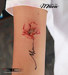 a woman's arm with a flower on it and the word mom written in cursive writing