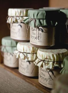 several jars are stacked on top of each other with ribbons tied around the lids and labels